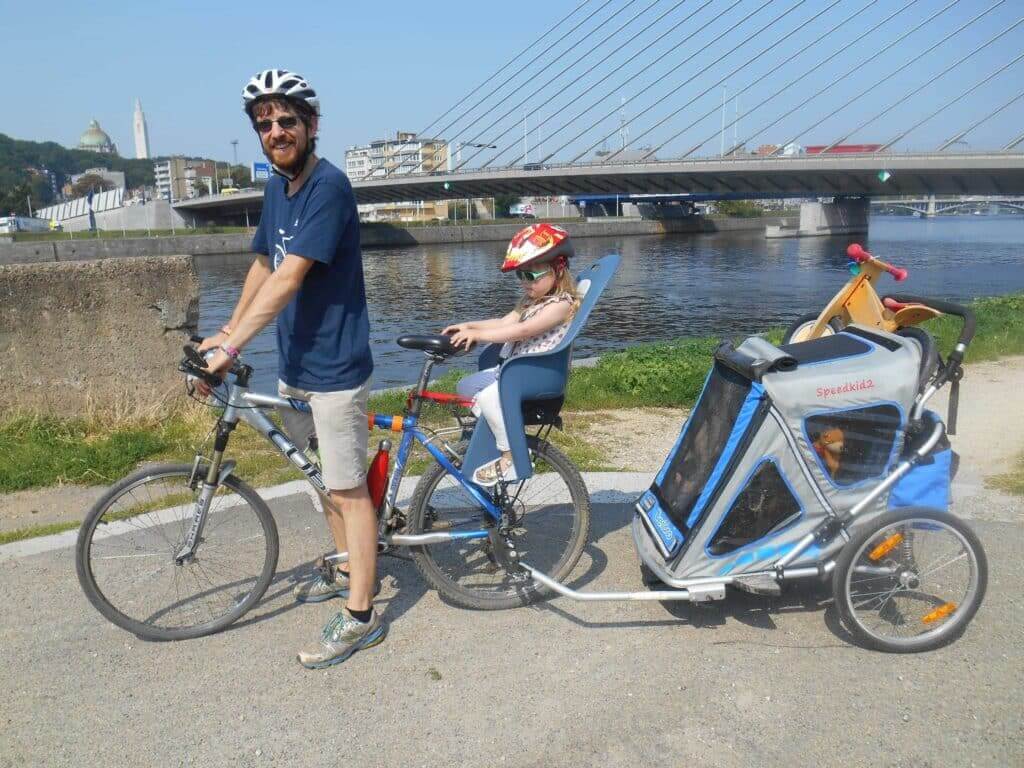 Transporter les enfants à vélo.
Photo de moi sur mon vélo tirant ma fille sur le siège enfant sur le porte-bagage et une remorque avec ma deuxième fille et sa draisienne.