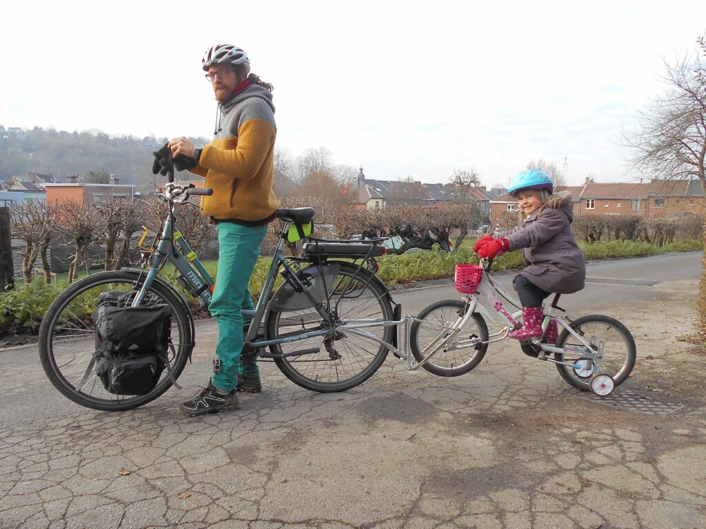 Photo de moi sur mon vélo avec le follow-me et ma fille dessus... Là, elle est active dans le mode de déplacement et elle apprend à faire du vélo.